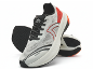 Paar witte en rode sportschoenen met zwarte veters en zolen, één rechtopstaand.