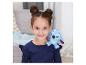 Une fille souriante avec deux chignons et une peluche Stitch sur son épaule.