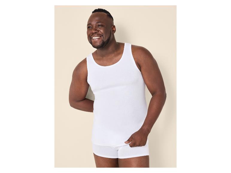 Man in wit hemd en boxershort, lachend.