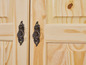 Twee houten deuren met bewerkte messing handgrepen.