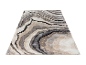 Tapis moderne à motifs marbrés, tons beige et gris.