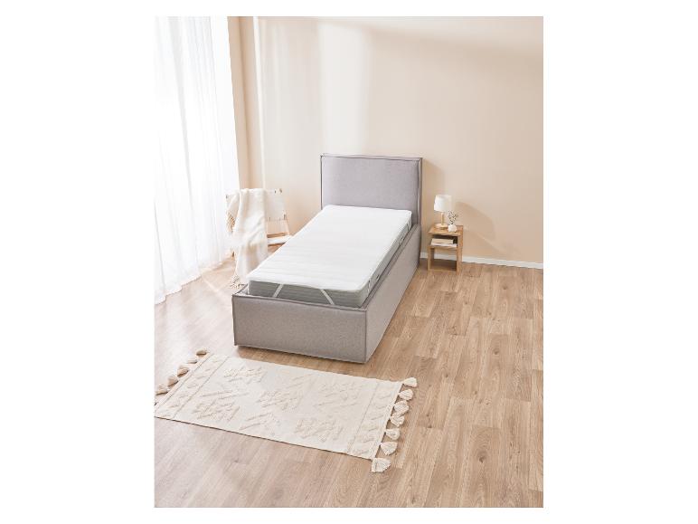 Lit avec matelas et protège-matelas, dans une chambre moderne.