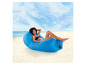 Een vrouw die ontspannen op een blauwe opblaasbare loungestoel ligt op het strand.