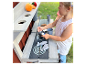 Kind speelt met een speelkeuken en accessoires.