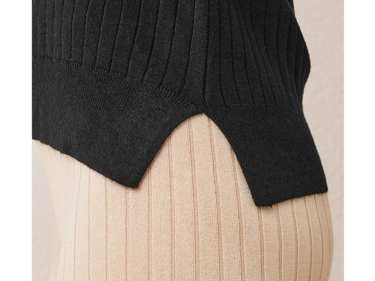 Un haut en maille noir sur un pantalon beige côtelé.