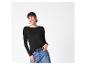 Vrouw in een zwart shirt met lange mouwen, blauwe jeans en een zwarte riem, lachend.