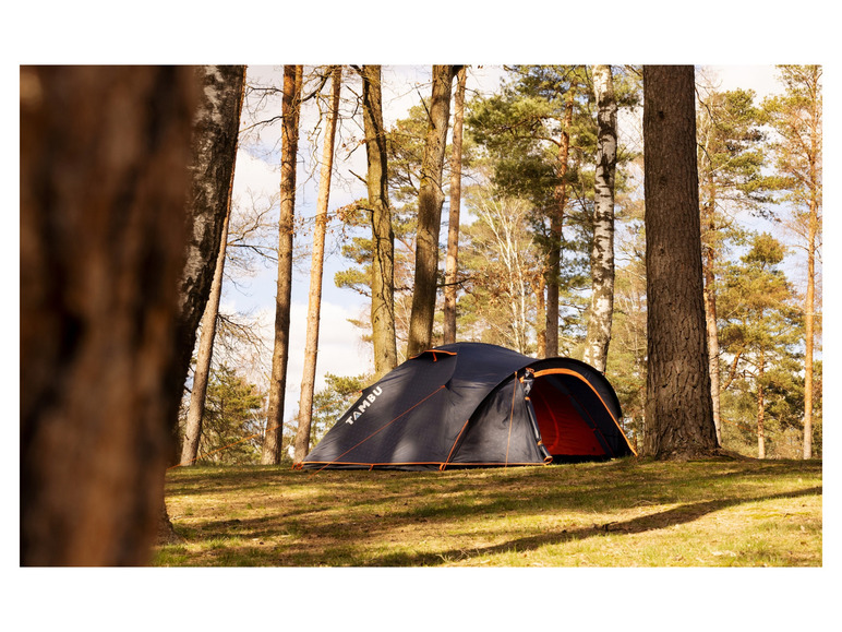 Een zwarte Tambu tent in een bosrijk gebied.