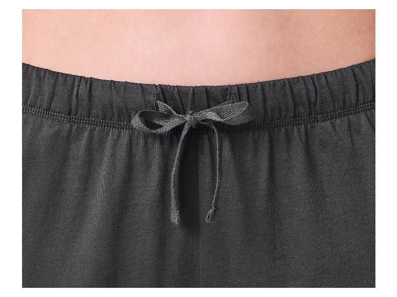 Gros plan de la taille d'une personne portant un pantalon de survêtement gris foncé avec un cordon.