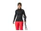 Vrouw in zwarte en rode ski-uitrusting, met skibril en skistokken.
