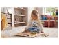 Enfant jouant avec un puzzle en bois de formes géométriques sur un tapis.