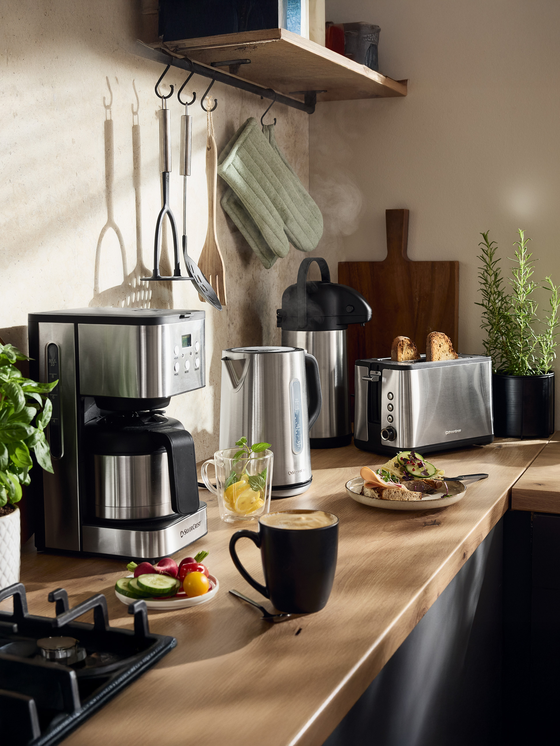 SilverCrest koffiezetapparaat, waterkoker en broodrooster in een keuken met eten en drinken.