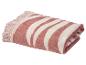 Opgevouwen roze en wit gestreepte strandhanddoek met franjes.