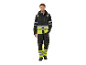 Un homme souriant porte une tenue de travail noire et jaune haute visibilité.