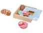 Jouets en bois avec gâteaux et beignets dans une boîte.