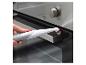 Een hand die een elektrische reinigingsborstel gebruikt om een oven schoon te maken.