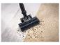 Brosse d'aspirateur nettoyant la saleté d'un tapis et du carrelage.