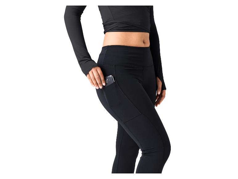 Vrouw in zwarte sportlegging met zijzak en bijpassende top met lange mouwen.