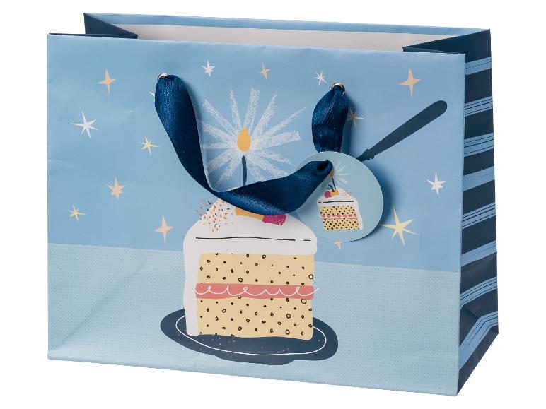 Sac cadeau bleu avec gâteau d'anniversaire, bougies et étoiles, avec étiquette cadeau cupcake.