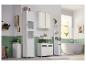 Een moderne badkamer met witte opbergkasten, een vrijstaand bad en groene tegelwanden.