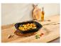 Épis de maïs rôtis au piment et citron vert dans un plat de cuisson noir sur un comptoir en bois.