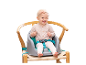Baby in een kinderstoel met veiligheidsgordel.