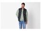 Zwart gewatteerd herenvest, lichtgroene sweater en jeans