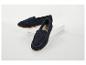 Deux mocassins en daim bleu marine à semelles marron, l'un devant l'autre sur une surface blanche.
