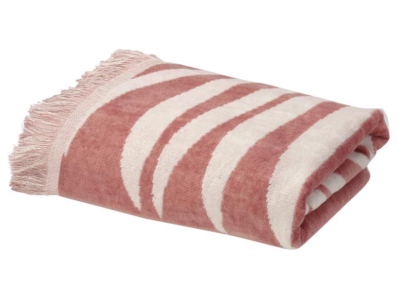 Opgevouwen roze en wit gestreepte strandhanddoek met franjes.