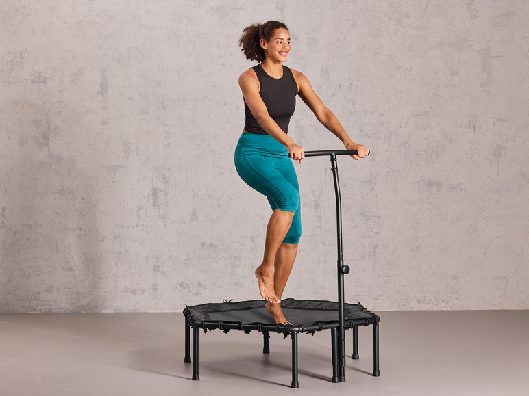 Een vrouw die op een kleine trampoline met handvat springt