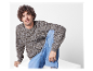 Man met krullend haar in een gebreide trui en jeans.