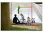 Een gezin geniet van een dagje uit aan het meer onder een tent.