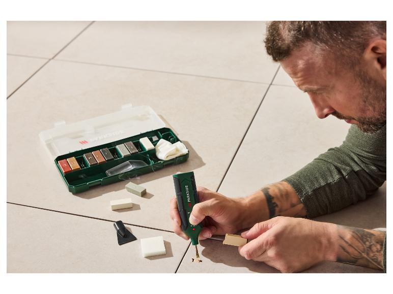 Man gebruikt een PARKIDE reparatieset om een gat in een lichte vloer te vullen.