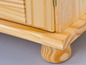 Een houten kast met een paneeldeur en gedraaide poten.
