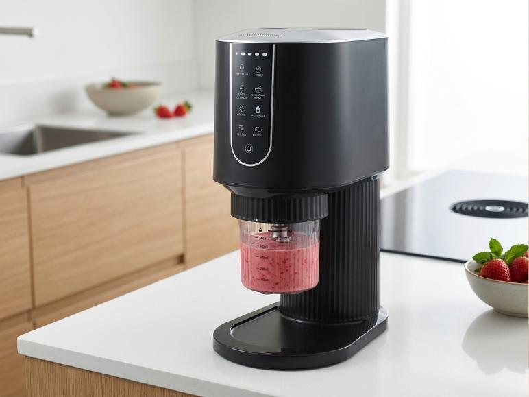 Machine à glace noire avec smoothie aux fraises dans une cuisine moderne.