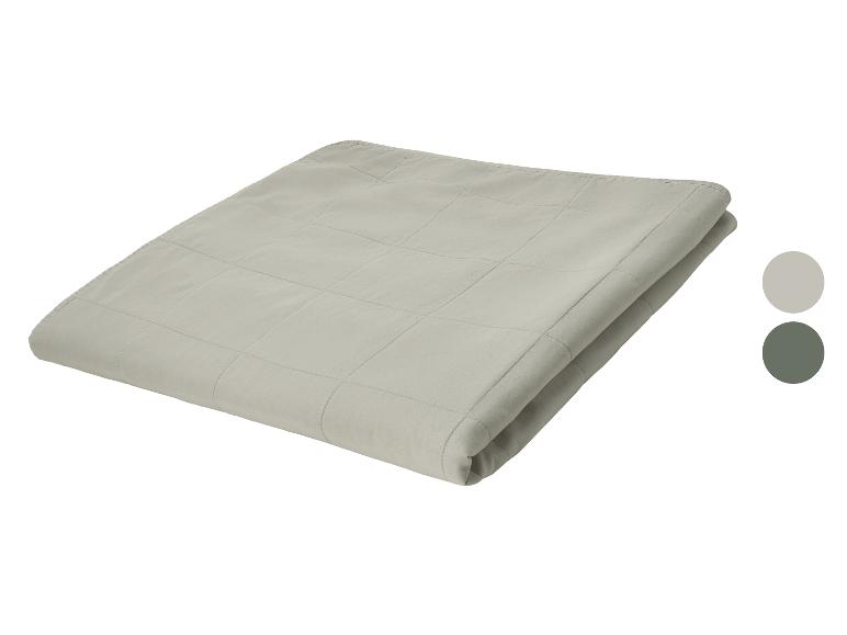 Couverture matelassée gris clair pliée, avec des échantillons de couleur gris clair et vert foncé.