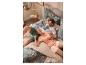 Koppel in tropische pyjama ontspant op bed met een beige plaid.