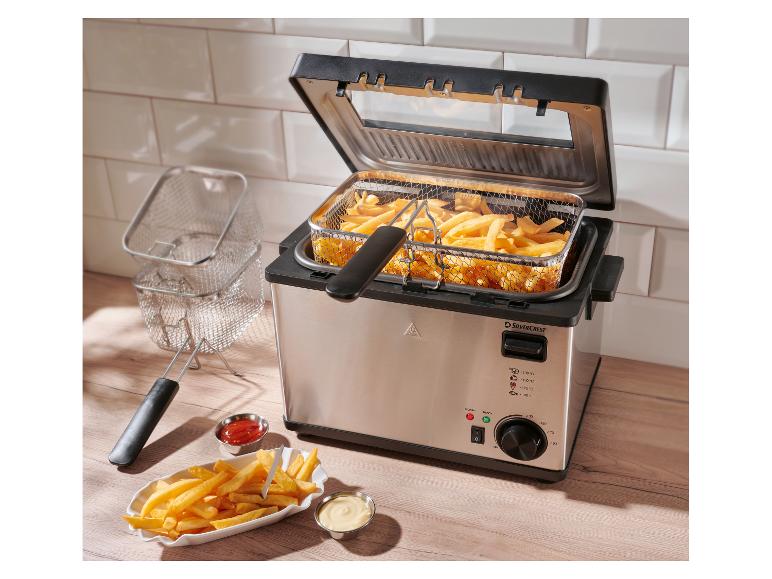 SilverCrest friteuse met friet en sauzen op een houten plank