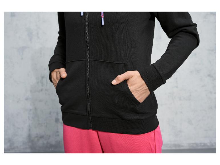 Een zwart hoodie met rits en roze broek.