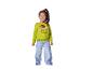 Petite fille souriante dans un pull vert Grinch et un jean bleu.