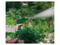 Hand houdt groene tuinspuit vast, spuit water in een tuin.