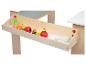 Een houten lade met rollenspel speelgoed: fruit en krijt.