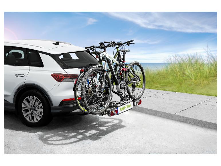 Twee mountainbikes op een fietsendrager achter een witte SUV.