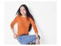Femme en pull orange et jeans.