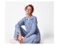Femme rousse en ensemble pull et pantalon bleu, assise sur le sol.