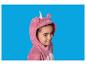 Meisje in een roze eenhoornpyjama, lachend op een blauwe achtergrond.