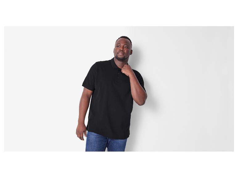 Een man draagt een zwart poloshirt.