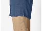 Donkerblauw denim overhemd en beige broek.