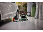 Auto op krik met gereedschap, lader en rolwagen in garage.