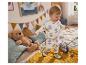Een baby in kleding met bloemenprint speelt op bed.