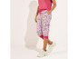 Femme portant un pantalon blanc à imprimé léopard et des baskets blanches.
